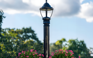 Decorative solar pole with a classic lantern-style fixture and hanging flower baskets.
