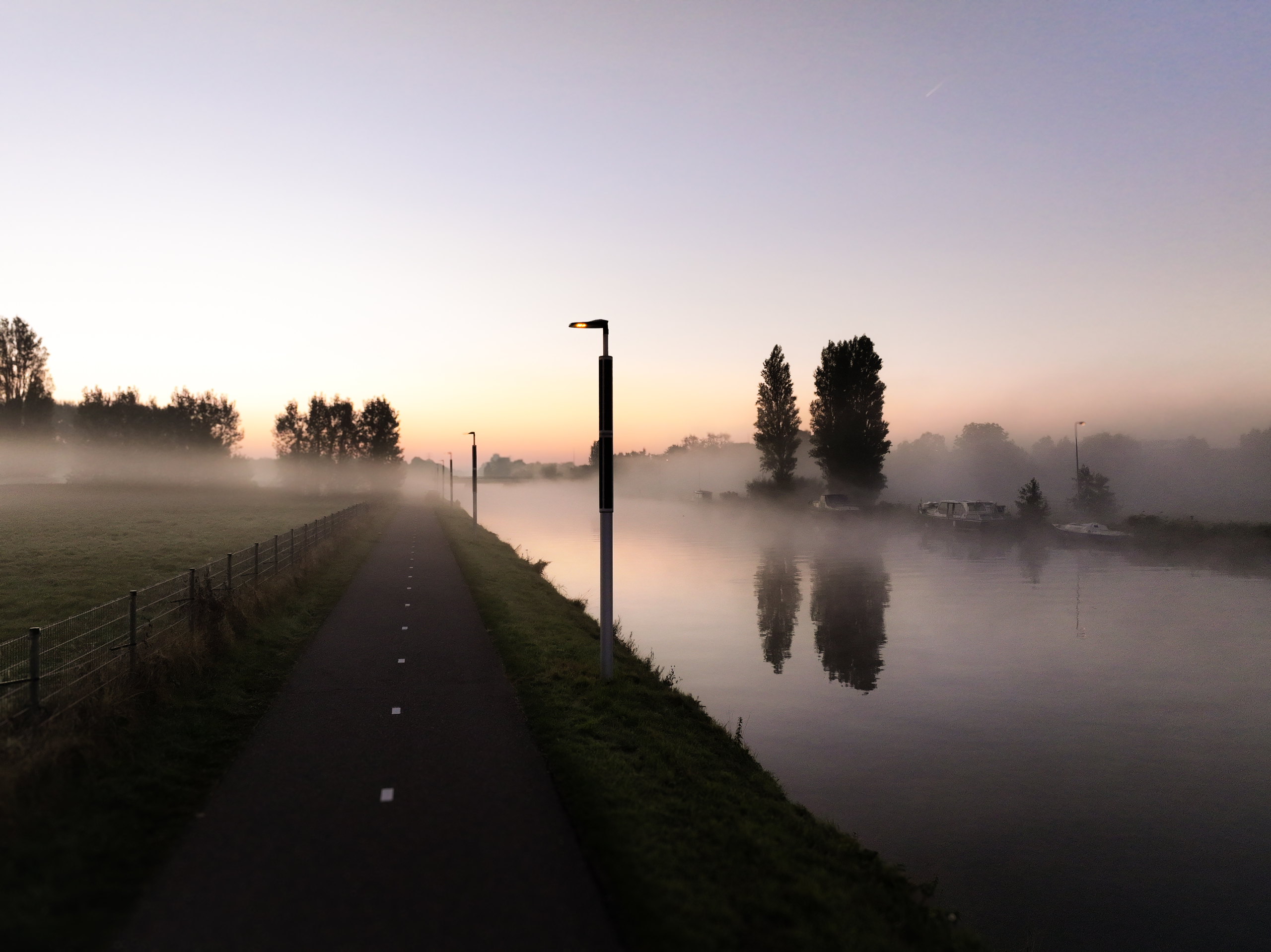 Soluxio wildlife-friendly lighting beside a canal in Waddinxveen at dawn in a misty environment.